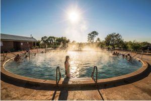 Woman enjoying a relaxing day in a naturally heated thermal pool at the Artesian Bore Baths, Lightning Ridge.