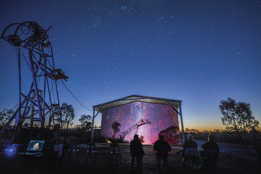 People enjoying the SPARK open air cinema under the night sky at the Australian Opal Centre, Lightning Ridge.
